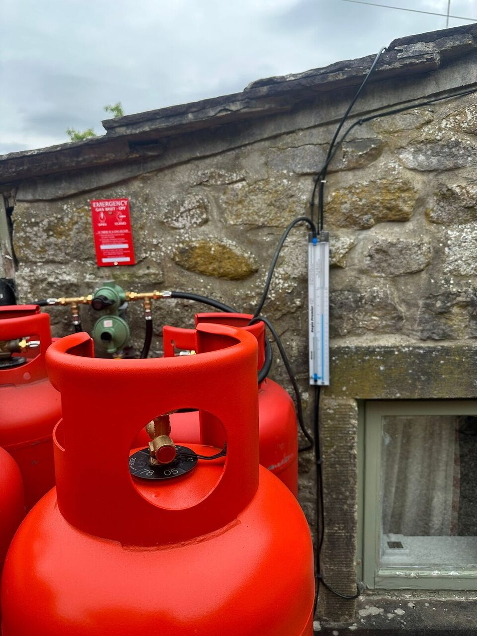 Red Calor LPG cylinders with newly fitted regulators and hoses on rural Lancashire property